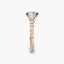 Rose gold ring with a cushion-shaped diamond and smaller round diamonds on a white background