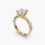 Gold ring with a large cushion cut diamond and smaller marquise shaped and round cut diamonds on the band against a white background