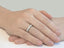 Emerald diamond eternity wedding band on the women's hand white gold