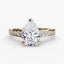 Gold ring with a pear-shaped diamond on a white background