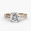 Rose gold round diamond ring with a large central gemstone and smaller stones on the band against a white background
