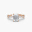 Rose gold ring with a large emerald cut diamond and smaller diamonds on the band against a white background