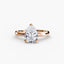 Rose gold ring with a pear-shaped diamond on a white background