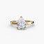 Gold solitaire ring with a pear-shaped diamond on a white background