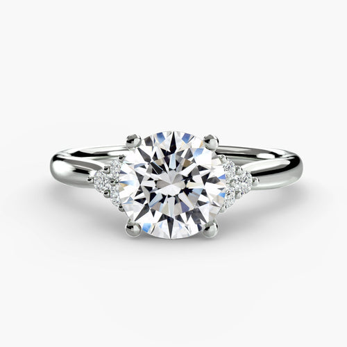 Round diamond solitaire engagement ring with three round side stones white gold on a white background
