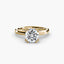 Gold solitaire engagement ring with a round brilliant cut diamond on a white background