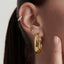 Close-up of an ear wearing gold hoop diamond earrings