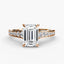 Rose gold ring with a large emerald cut diamond and smaller round diamonds on the band against a white background
