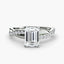 White gold ring with a large emerald-cut diamond and smaller diamonds on the twisted band against a white background