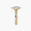 Gold ring with a marquise diamond and twisted diamond pave band on a white background