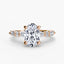 Rose gold ring with a large oval diamond and smaller marquise and round diamonds on the sides against a white background