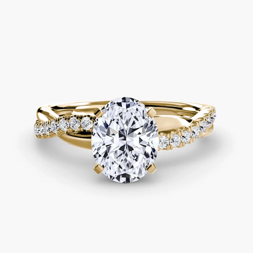 Gold ring with a large oval diamond and smaller diamonds on the twisted band against a white background