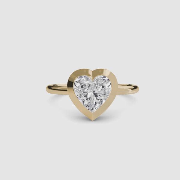 Heart-shaped diamond bezel ring with yellow gold solitaire setting 