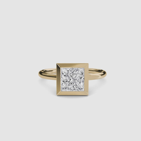 Bezel solitaire gold ring with a princess-cut diamond