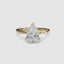 Solitaire gold ring with a pear-shaped diamond on a white background