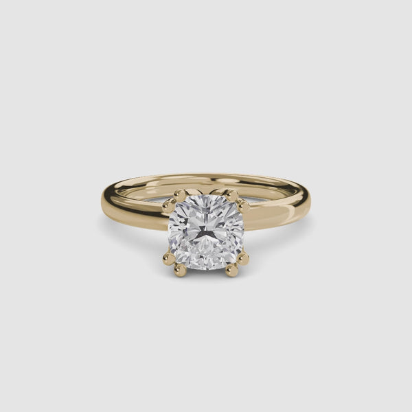 
360 view of the Solaris cushion-cut diamond solitaire engagement ring in 14k yellow gold, featuring a large cushion-cut diamond secured by eight ball-tipped prongs in a floral basket setting with a plain polished tapered band.