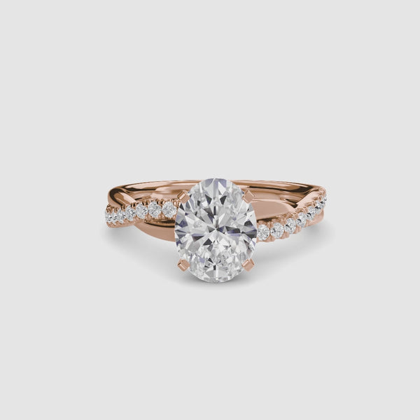 Rose gold ring with a oval center diamond and twisted pave shank on a white background