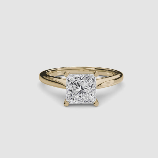 Gold ring with a large princess-cut diamond on a white background