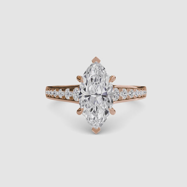 Diamond ring with a marquise-shaped center stone on a white background
