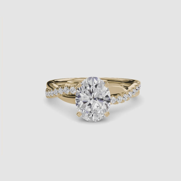 Gold ring with a large oval diamond and smaller diamonds on the twisted band against a white background
