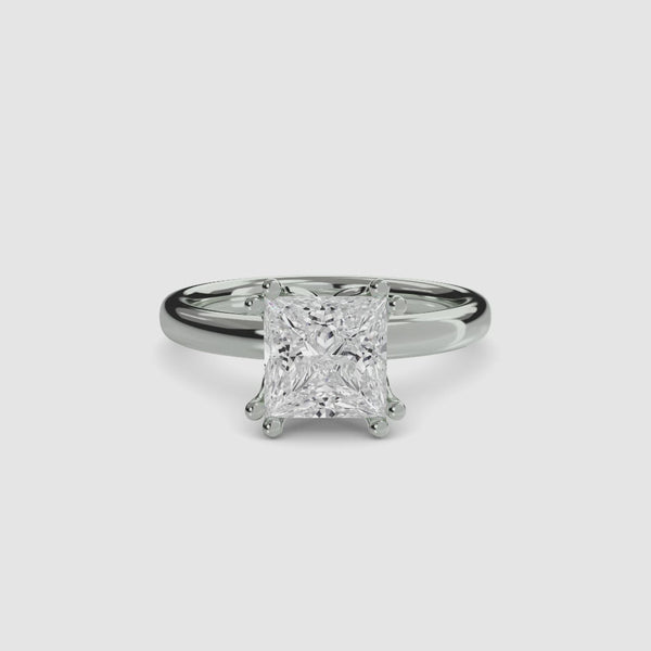 360 view white gold solitaire engagement ring featuring a large princess-cut diamond secured by eight ball-tipped prongs in a floral basket setting, with a plain polished tapered band.