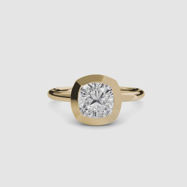 Cushion cur bezel set ring in yellow gold solitaire setting
