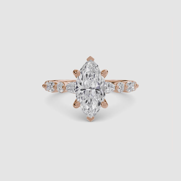 Rose gold ring with a marquise-cut diamond on the center and side stones marquise round on a white background