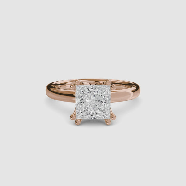 
360 view of a rose gold solitaire engagement ring featuring a large princess-cut diamond secured by eight ball-tipped prongs in a floral basket setting, with a plain polished tapered band