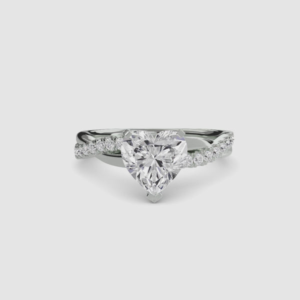 White gold ring with a heart-shaped diamond twisted pave band on a white background