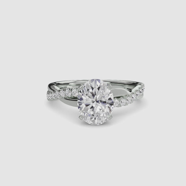 White gold ring with a oval center diamond and twisted pave shank on a white background