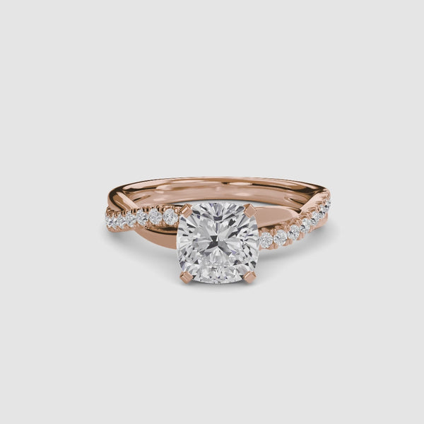 White gold ring with a large cushion-cut diamond and smaller diamonds on the twisted band against a white background