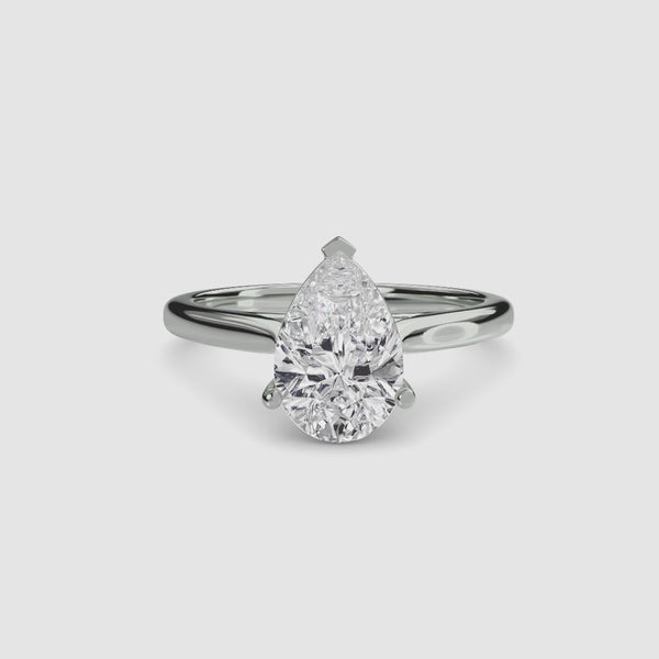 Solitaire white gold ring with a pear-shaped diamond on a white background