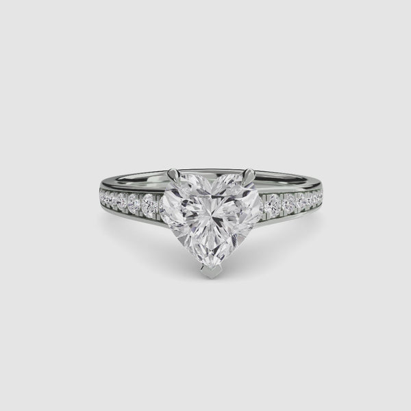 Diamond ring with a heart-shaped center stone on a white background