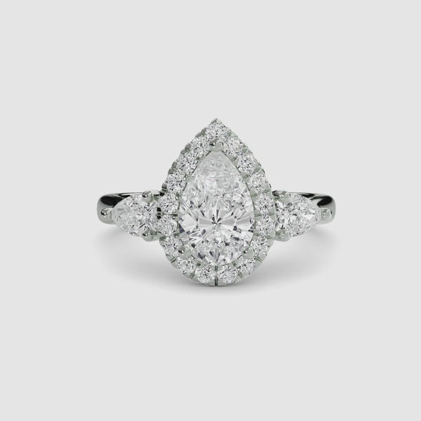 Halo Three Stone Diamond ring with a pear-shaped center stone in white gold
