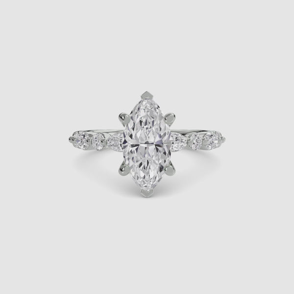 White gold ring with a marquise-cut diamond on the center and side stones marquise and round on a white background