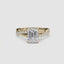 Gold ring with a large emerald-cut diamond and smaller diamonds on the twisted band against a white background