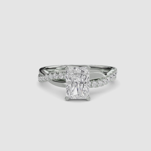 White gold ring with a radiant cut diamond twisted pave shank on a white background
