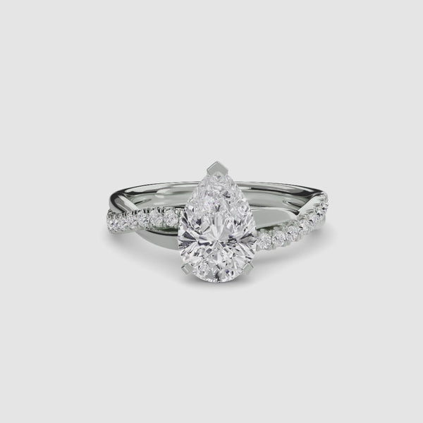White gold ring with a pear-shaped diamond twisted pave shank on a white background.