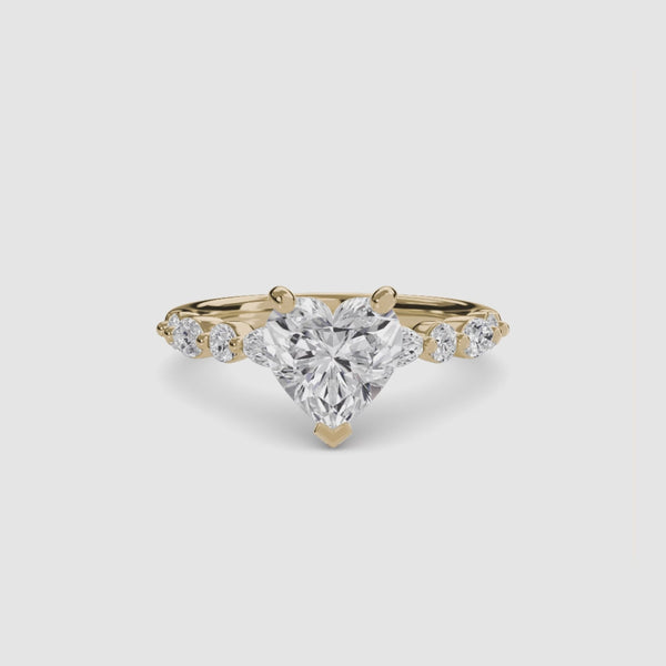 Heart-shaped diamond ring with gold setting on a white background