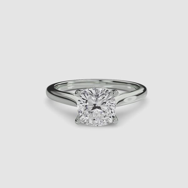Solitaire white gold ring with a cushion-cut diamond on a white background