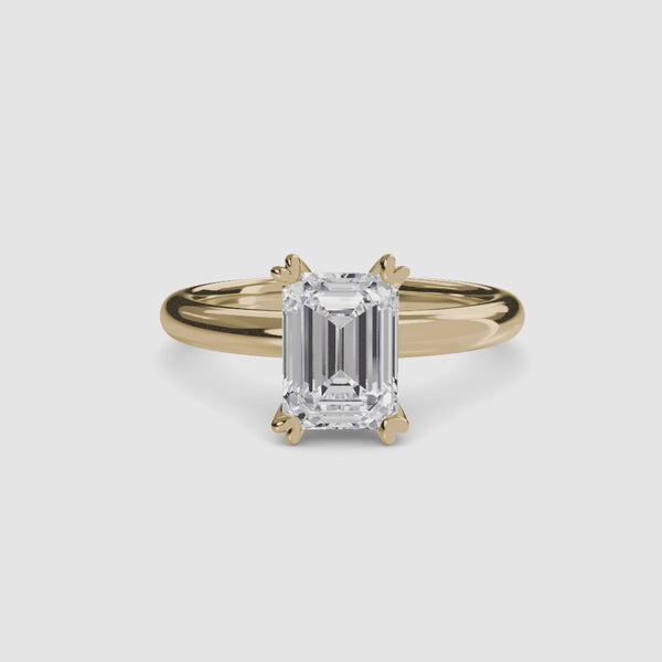360-degree rotation view the Sylvene emerald cut diamond double prong solitaire engagement ring in yellow gold