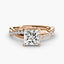 Rose gold ring with a large princess-cut diamond and smaller pave diamonds on the twisted band against a white background