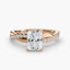 Rose gold ring with a radiant cut diamond and twisted pave shank on a white background