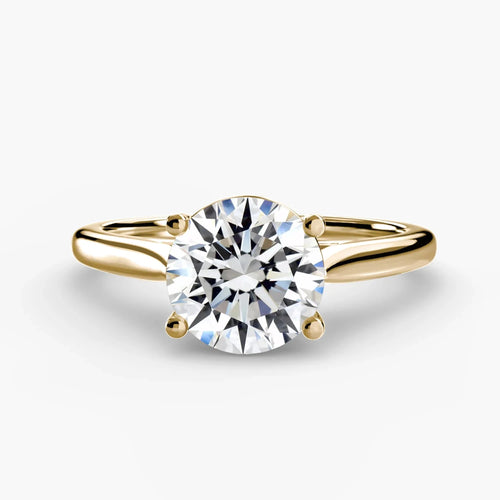 Gold solitaire ring with a round diamond brilliant cut on a white background