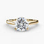 Gold solitaire ring with a round diamond brilliant cut on a white background