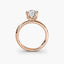 Front-facing view of a rose gold solitaire engagement ring with a round diamond in an eight-prong tulip basket setting, showcasing the open gallery and plain rounded band against a light gray background.