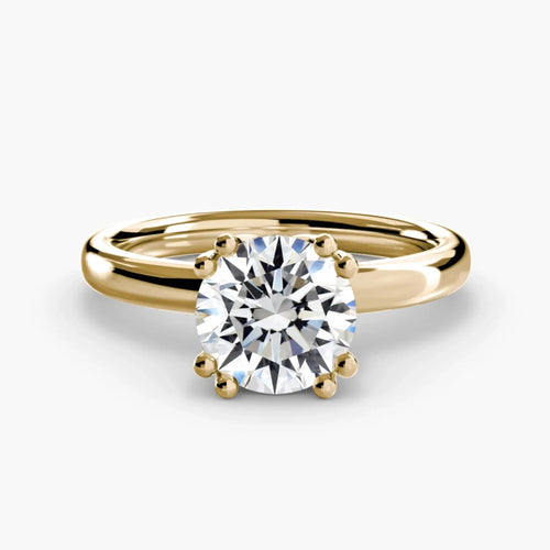 Top-down view of a yellow gold solitaire engagement ring featuring a large round brilliant-cut diamond secured by eight ball-tipped prongs in a floral basket setting, with a plain polished tapered band.