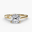 Solitaire gold ring with a cushion-cut diamond on a white background