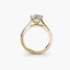 Solitaire gold ring with a diamond on a white background
