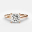 Rose gold solitaire ring with a large princess-cut diamond on a light gray background